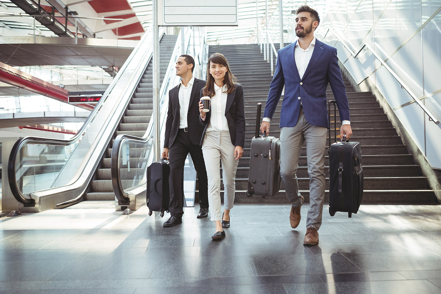 Businesses executives walking on stairs outside platform Group of business travellers